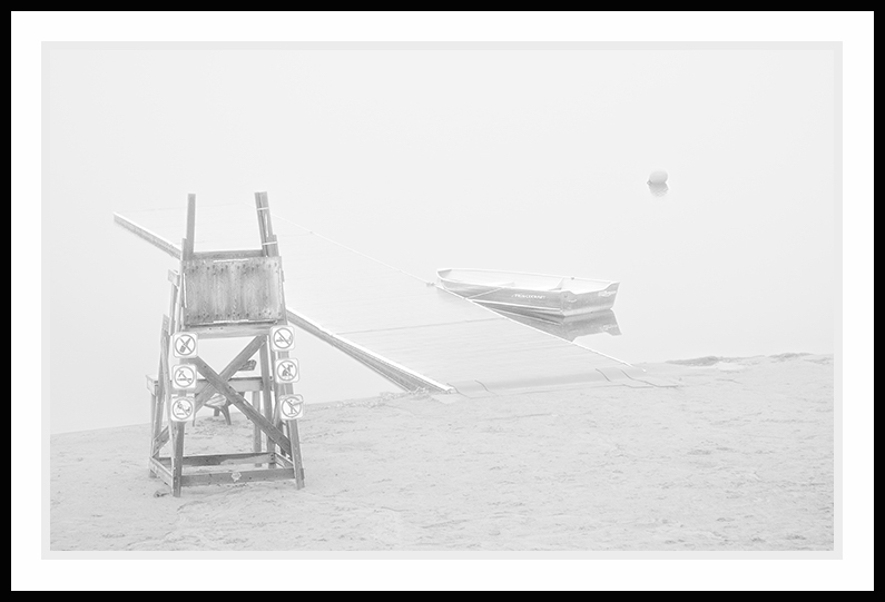 A foggy beach at the waters edge.